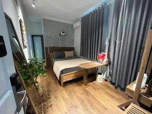 a small bedroom with a bed and a table at Choco village 126A in Xã Thang Tam