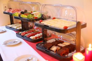 ein Buffet mit mehreren Tabletts Essen auf dem Tisch in der Unterkunft Hotel Ariana in Köln