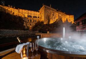 a hot tub with a bottle of champagne and wine glasses at Mill Apartments in Český Krumlov