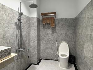 a bathroom with a shower with a toilet and a sink at Choco village 126A in Xã Thang Tam