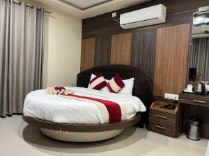 a bedroom with a large bed with red pillows at Shahi Land Hotel Pvt Ltd in Butwāl +3 photos