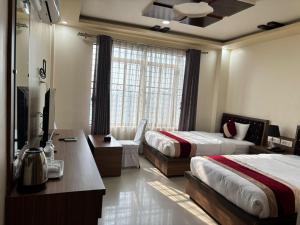 a hotel room with two beds and a television at Shahi Land Hotel Pvt Ltd in Butwāl