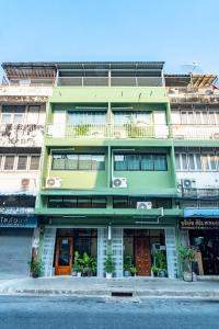 a green building on the side of a street at Baan Batra Heritage Suite in Bangkok