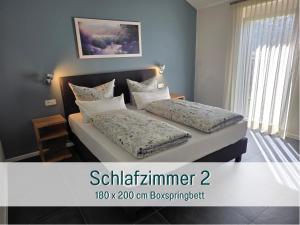 ein Schlafzimmer mit zwei Betten und Kissen darauf in der Unterkunft Traumweiler Ferienhäuser am Nationalpark Hunsrück Hochwald - barriearm - mit effektiver Kühlung in Kirschweiler