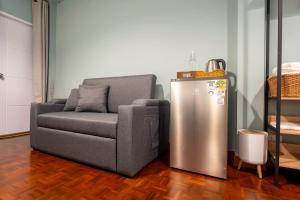 a living room with a couch and a refrigerator at Baan Batra Heritage Suite in Bangkok
