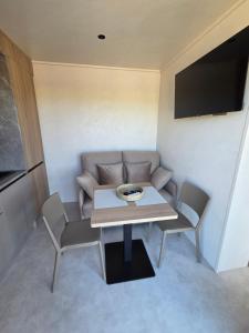 a small living room with a table and a couch at La roseraie in Abbécourt