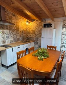 a kitchen with a wooden table and a white refrigerator at La Consentida in La Cabrera