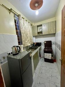 a small kitchen with a sink and a refrigerator at The perfect Hideout in Nairobi