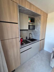 a kitchen with white cabinets and a sink at La roseraie in Abbécourt