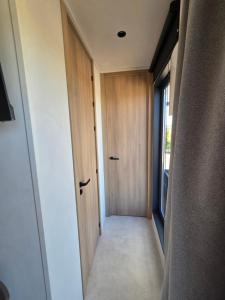 a hallway with a wooden door and a window at La roseraie in Abbécourt +2 photos