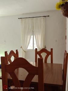 a dining room table and chairs with a window at casa el nacimiento in Igualeja