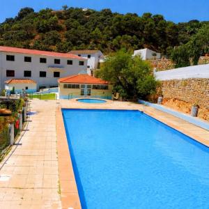 a large blue swimming pool next to a building at casa el nacimiento in Igualeja