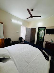 a bedroom with a large bed with a ceiling fan at Babuloos Homestay in Varkala
