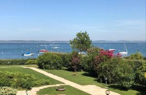 a garden with a view of the water and boats at Plage Pereire Arcachon vue sur mer in Arcachon