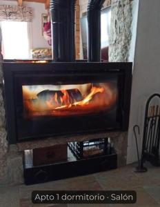 a fire in a fireplace in a living room at La Consentida in La Cabrera