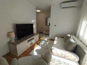 a living room with a couch and a flat screen tv at DežaVu in Ledine