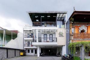 a white building with balconies on the side of it at Tree Homestay Mitra RedDoorz in Kasri