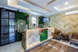 a lobby with a waiting area with plants on the wall at Tree Homestay Mitra RedDoorz in Kasri