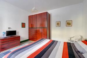 a bedroom with a bed and a dresser with a tv at The Englishmans Home in Cuglieri