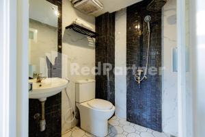 a bathroom with a toilet and a sink at Tree Homestay Mitra RedDoorz in Kasri +35 photos