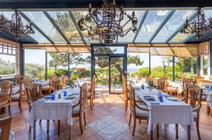 a dining room with white tables and chairs and windows at Hotel Le Bellevue, Demeures & Chateaux in Villerville