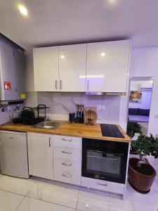 a kitchen with white cabinets and a stove top oven at BAS Garden Apartment Paralia in Paralia Katerinis +1 photo