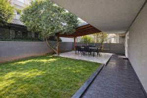 an outdoor patio with a table and chairs and grass at BAS Garden Apartment Paralia in Paralia Katerinis
