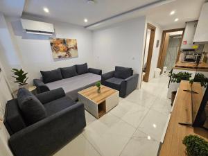 a living room with two couches and a table at BAS Garden Apartment Paralia in Paralia Katerinis