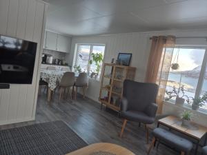 a living room with a table and chairs and a kitchen at Feriehuset Holmen in Straumen