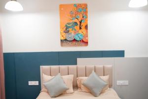 a bedroom with a painting above a bed with pillows at Vi Grand inn in Satyamangalam +91 photos