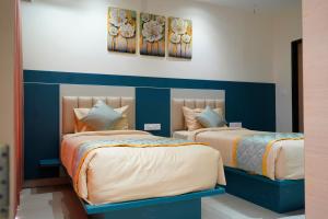 two beds sitting next to each other in a bedroom at Vi Grand inn in Satyamangalam