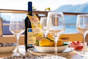 a bottle of wine and glasses on a table at Radonjić Apartments in Kotor +56 photos