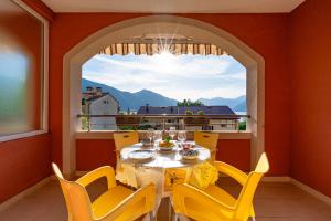 a dining room with a table and chairs and a window at Radonjić Apartments in Kotor