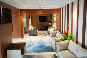 a living room with white couches and a living room at Vi Grand inn in Satyamangalam