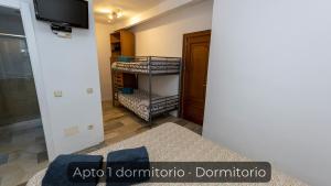 a room with a bunk bed and a tv at La Consentida in La Cabrera