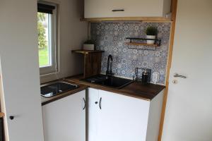 a small kitchen with two sinks and a window at Tinyhouse Rhön-Saale in Wülfershausen