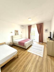 a large bedroom with two beds and a television at MangaRenga apartments in Šušanj