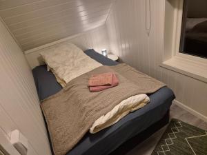 a small bed with a towel on it in a room at Feriehuset Holmen in Straumen