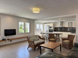 a living room with a table and chairs and a kitchen at Agi Las Acacias in Roses