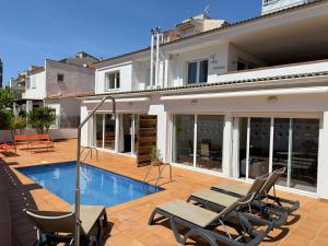 a villa with a swimming pool and patio furniture at Agi Las Acacias in Roses