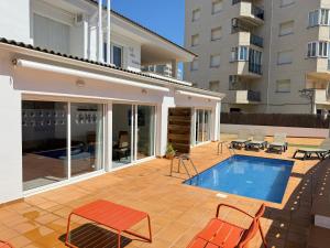 a patio with a swimming pool and a house at Agi Las Acacias in Roses