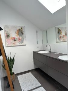 a bathroom with two sinks and a mirror at HofZeit 1 in Mechernich
