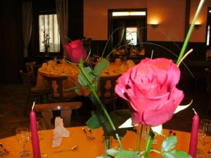 a pink rose in a vase on a table at Gasthaus zum Hirsch Hotel - Restaurant in Weier