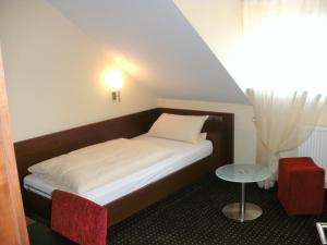 a small bedroom with a bed and a table at Gasthaus zum Hirsch Hotel - Restaurant in Weier