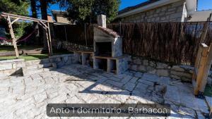 a stone oven in a yard next to a fence at La Consentida in La Cabrera +21 photos