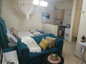 a living room with a blue couch and a kitchen at Soney Homes in Nairobi
