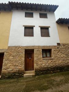a stone building with a wooden door and windows at Cases Tonet 3 in Forcall