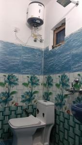 a bathroom with a toilet and a window in it at Hotel Raghunandan Palace in Phata +15 photos