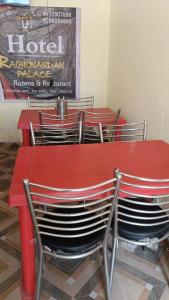 a red table and chairs in a room at Hotel Raghunandan Palace in Phata