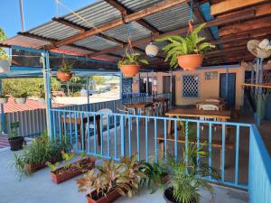 a patio with potted plants and tables and chairs at Hostel Samara in Sámara
